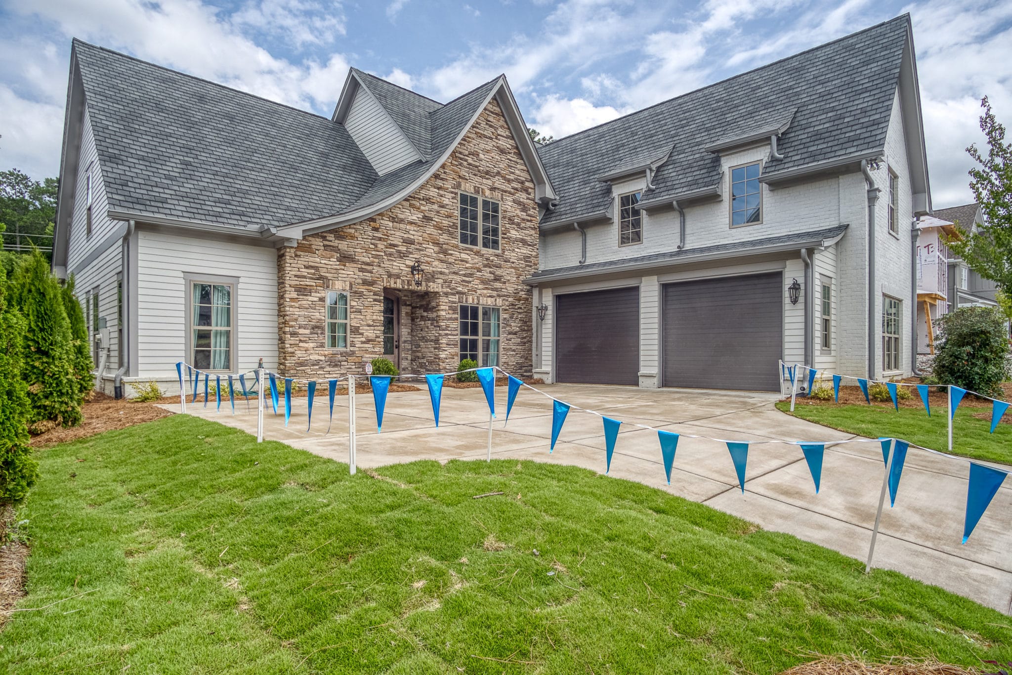 Picture of home driveway and garage port lined with blue flags.
