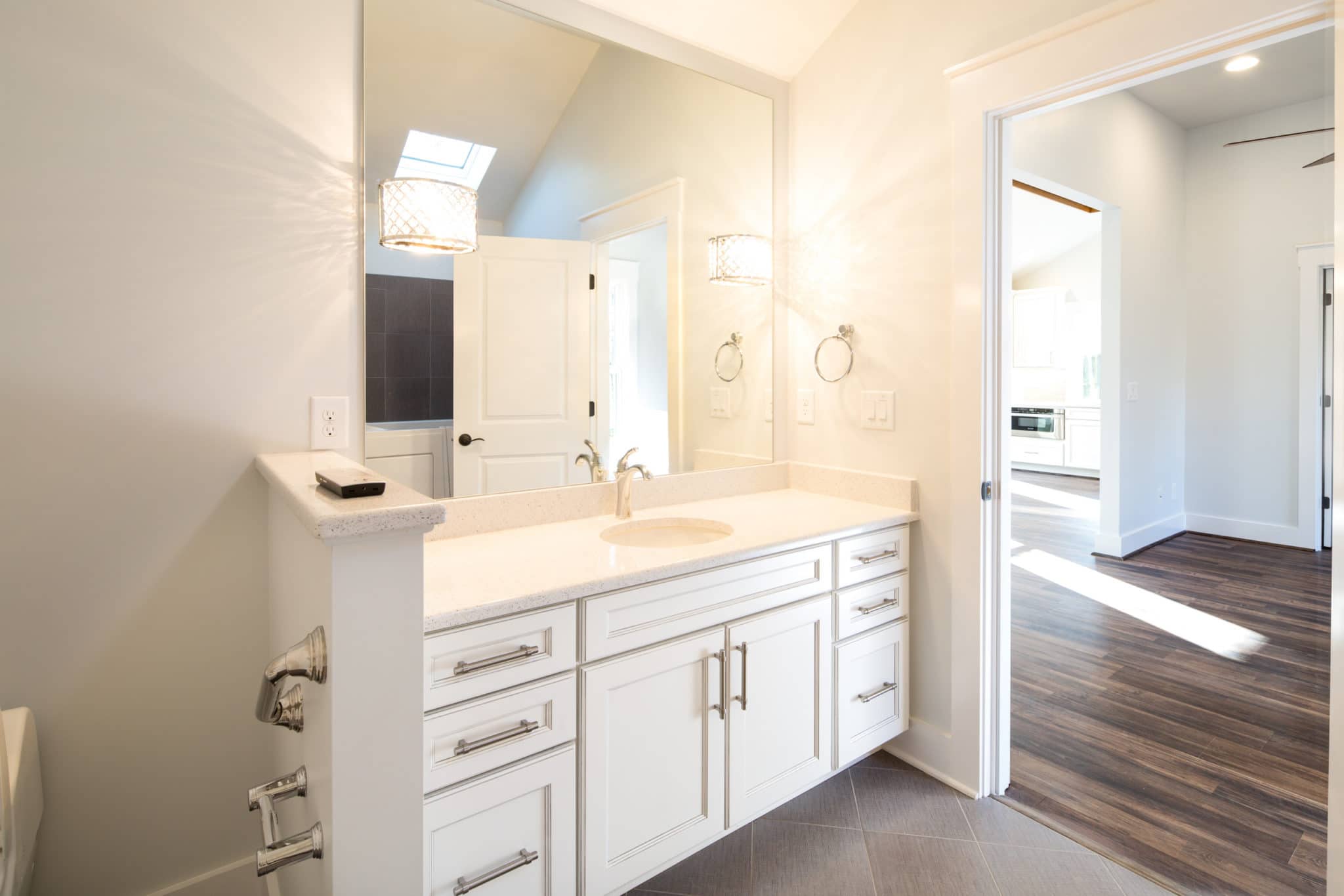 newly finished white bathroom with large vanity and mirror