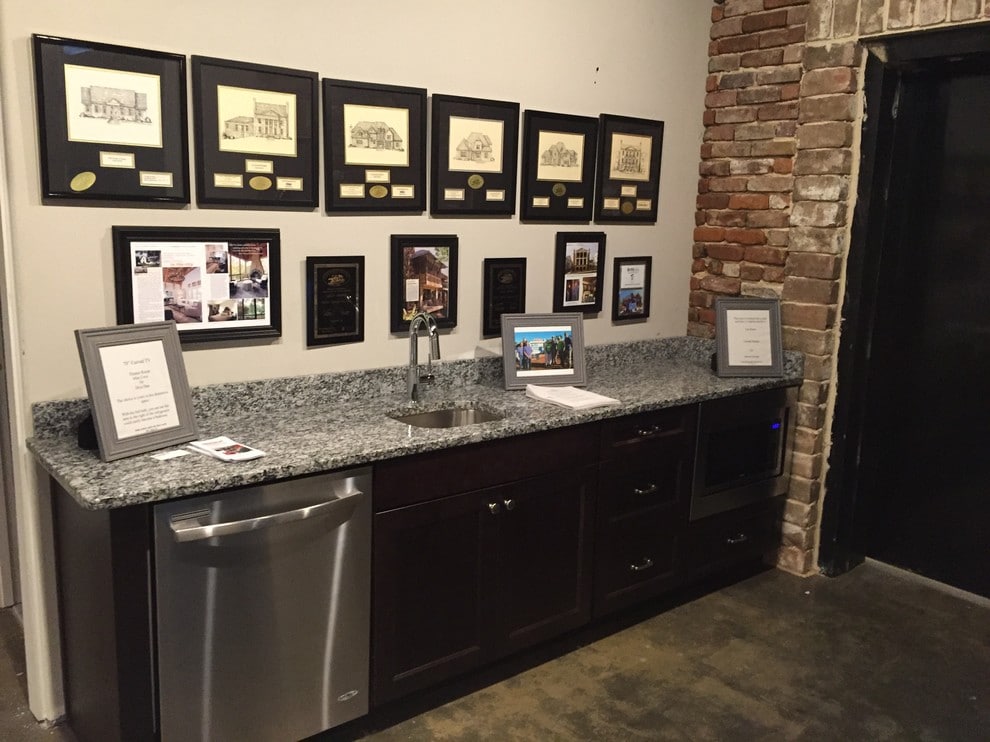 award-adorned wall and granite countertop with dishwasher