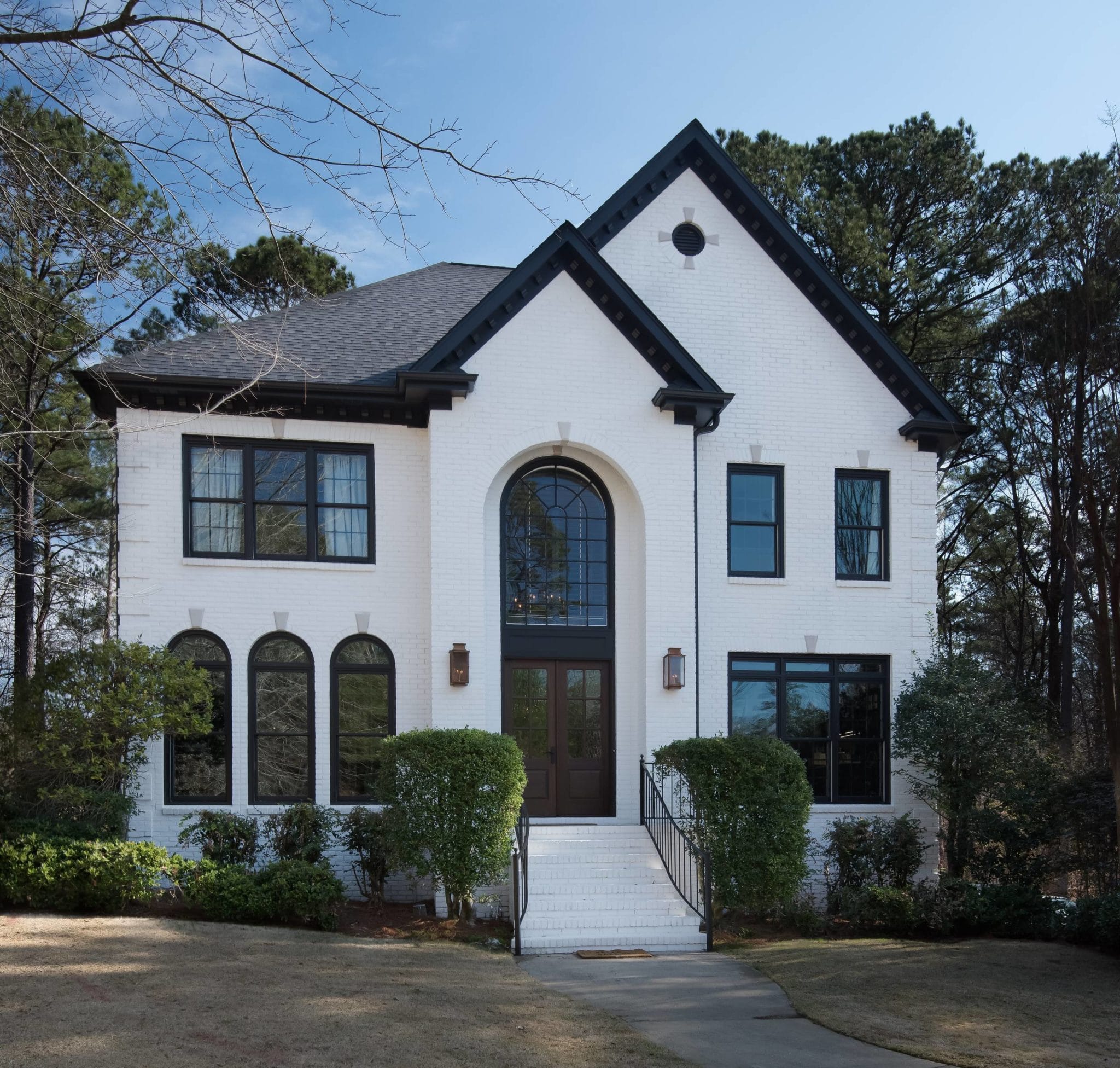 tall two story custom built white home with black accents