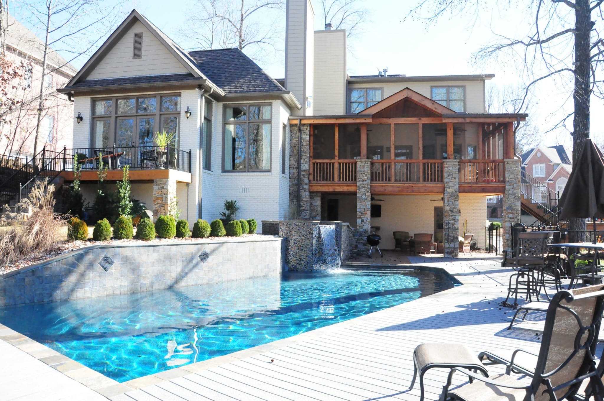 stylish swimming pool with waterfall and backyard patio