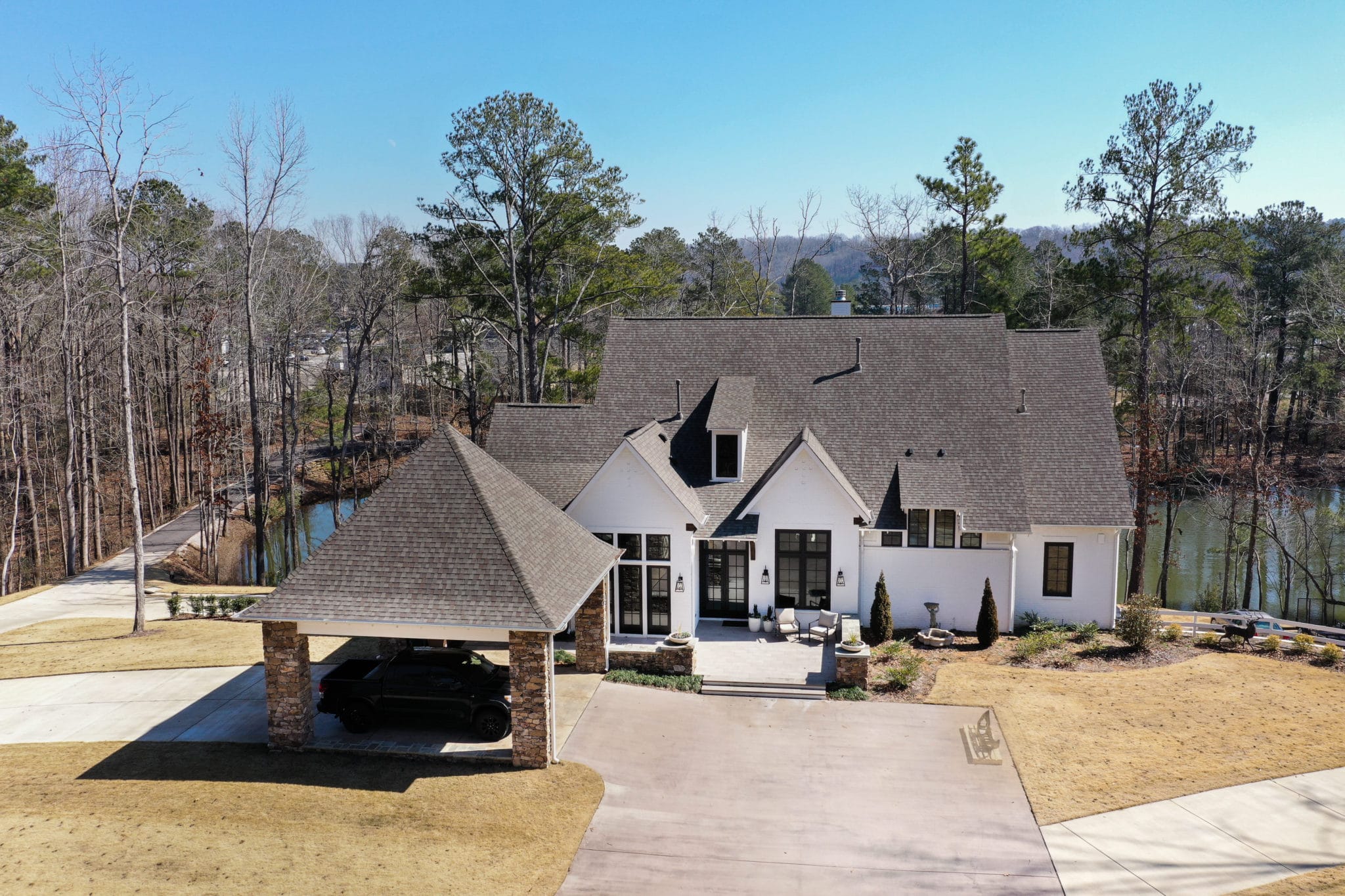 elevated view of white home with brick carport in the front